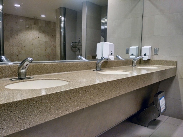commercial lavatory bathroom with sensor faucets