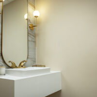 white marble sink with gold sensor faucet